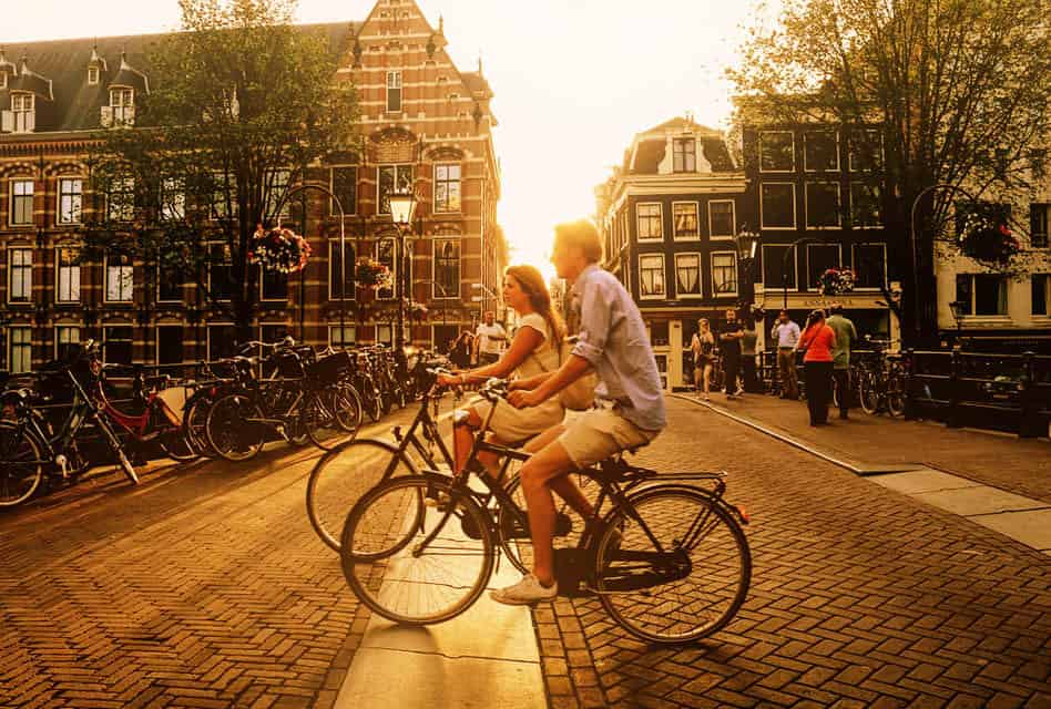 couple cycling over bridge in Amsterdam