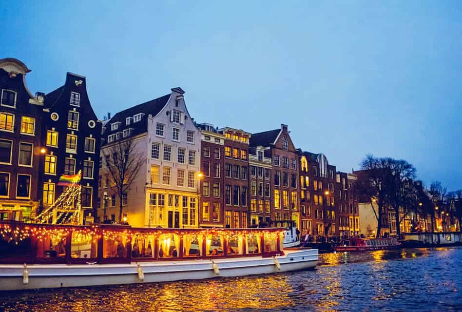 night boat lit up in amsterdam evening